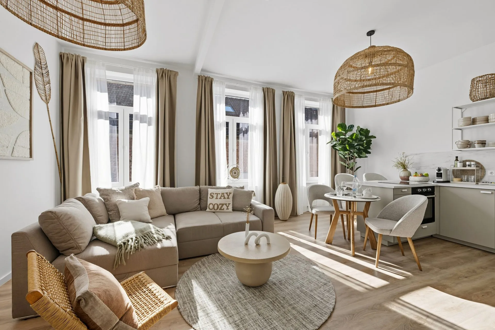 Wohnzimmer in Beige- und Sandtönen mit Rattanleuchten und Leinensofa