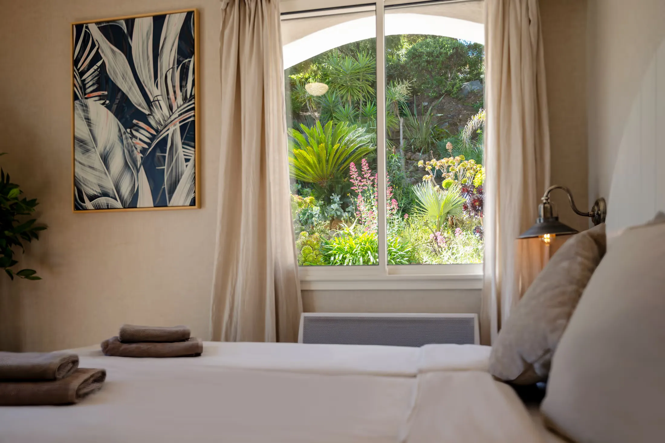 Schlafzimmer mit Fenster zum üppigen Garten