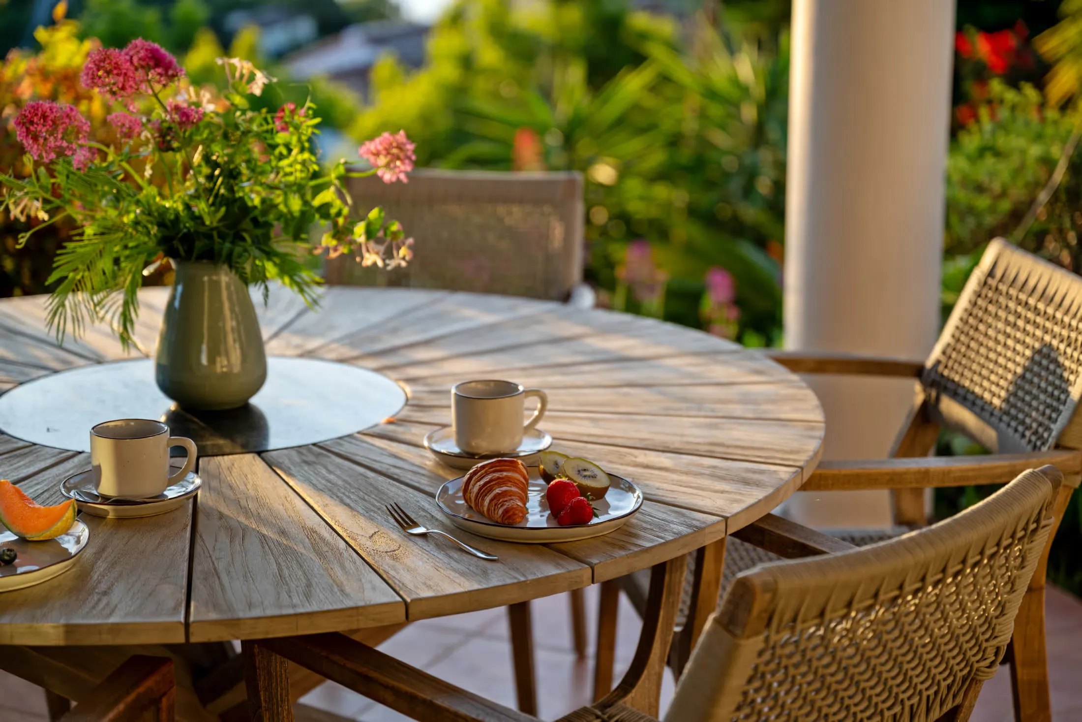 Gedeckter Frühstückstisch mit Kaffee und Blumen